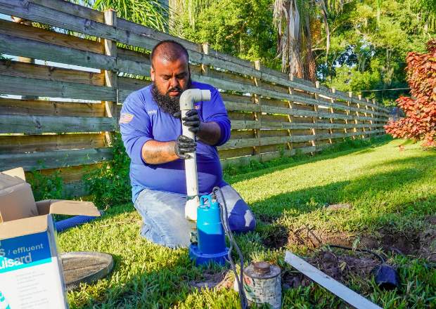Technician repairing septic system pipework