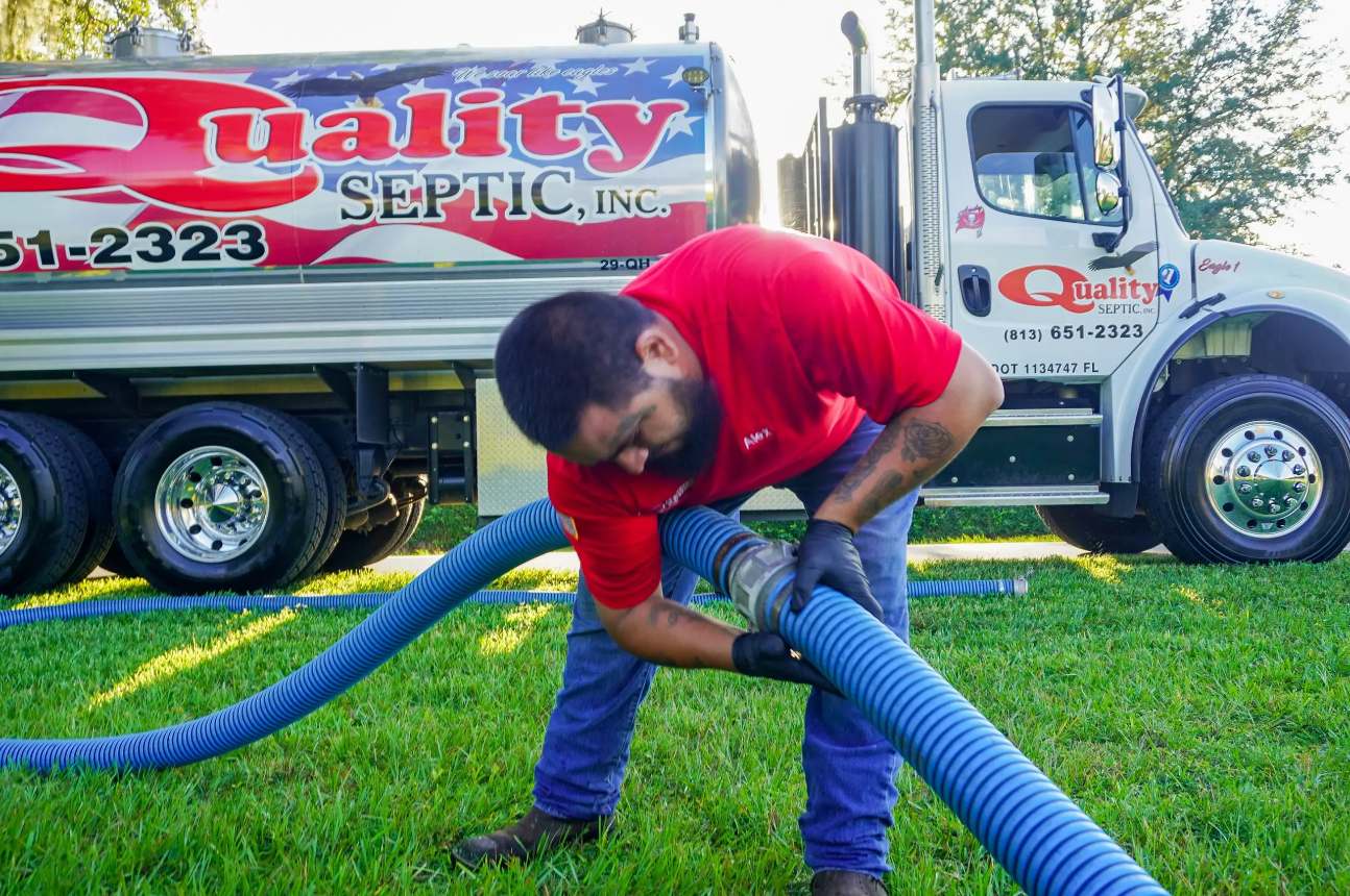 Quality Septic crew working beside branded service trucks