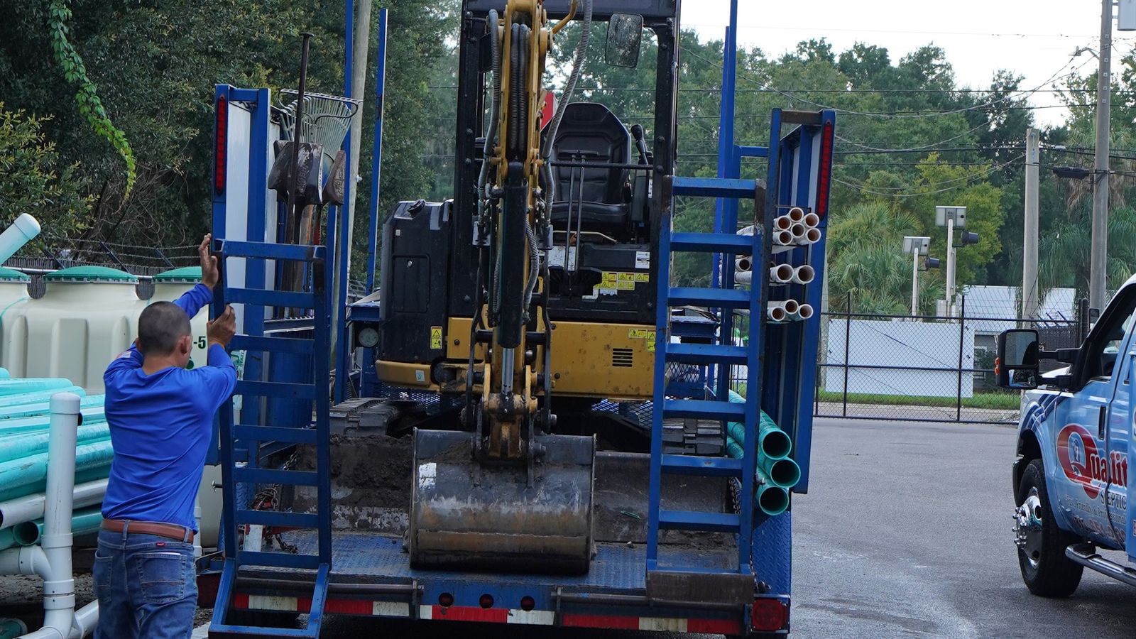 Loading the mini excavator the machine that does the digging on drain field and tank work